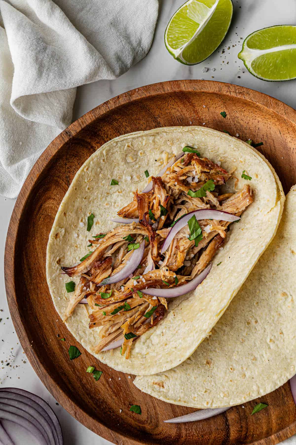 Flat lay shot of a wooden plate with Chipotle Carnitas Copycat Recipe in it.