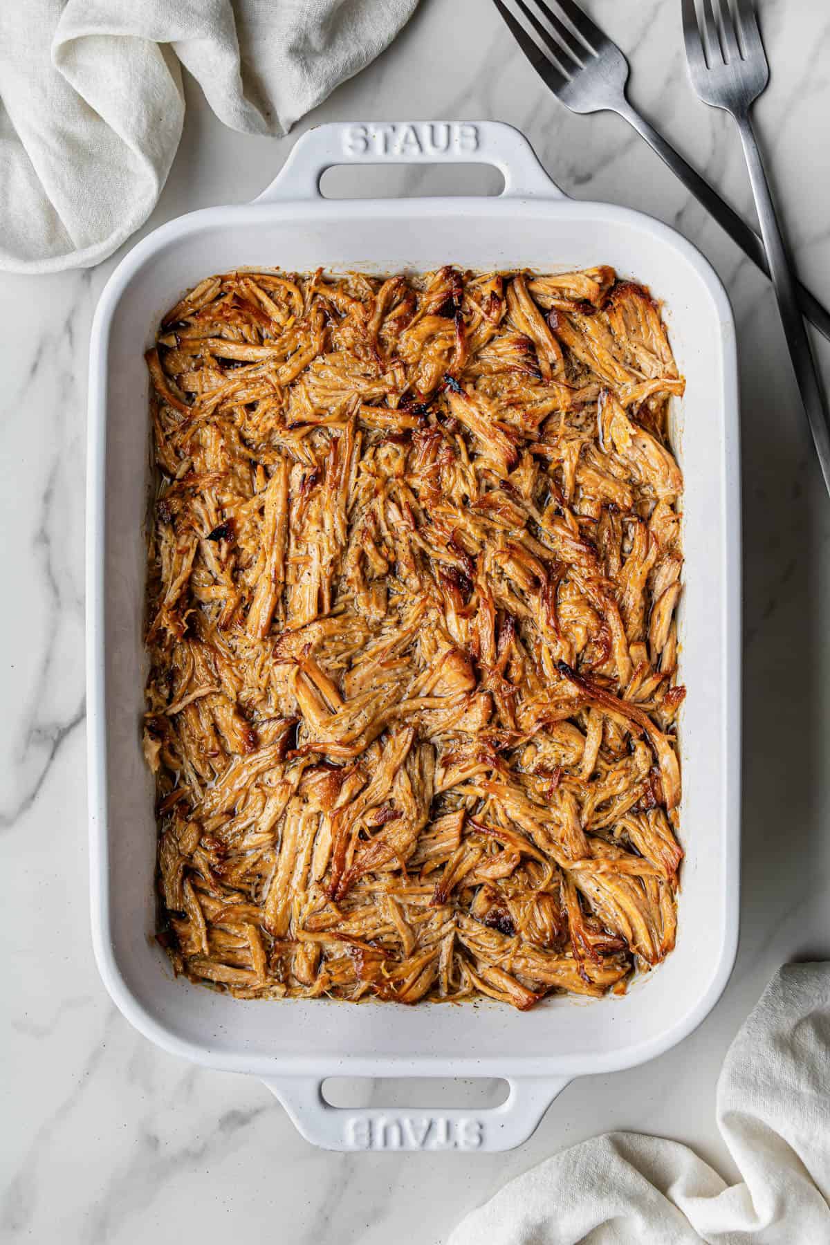 Flat lay shot of a white baking dish with the finished meat.