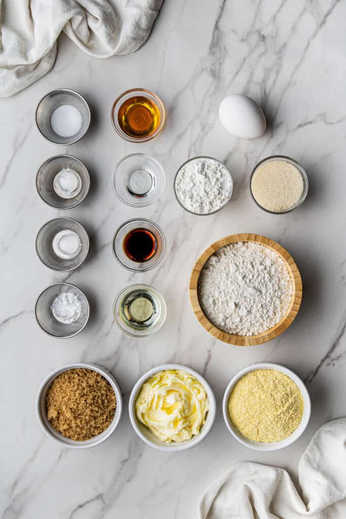 Flat lay shot of the ingredients for the Easy Crumbl Cornbread Cookie copycat Recipe. The ingredients are placed on separate bowls and placed on a marble surface.