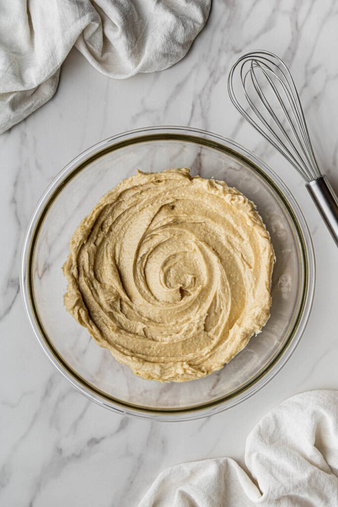 Flat lay shot of a glass bowl with whipped butter and sugars.