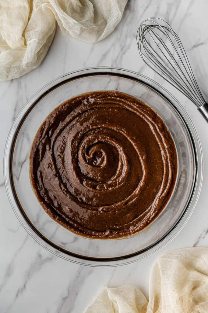 A glass bowl with a fudgy chocolate mixture in it.