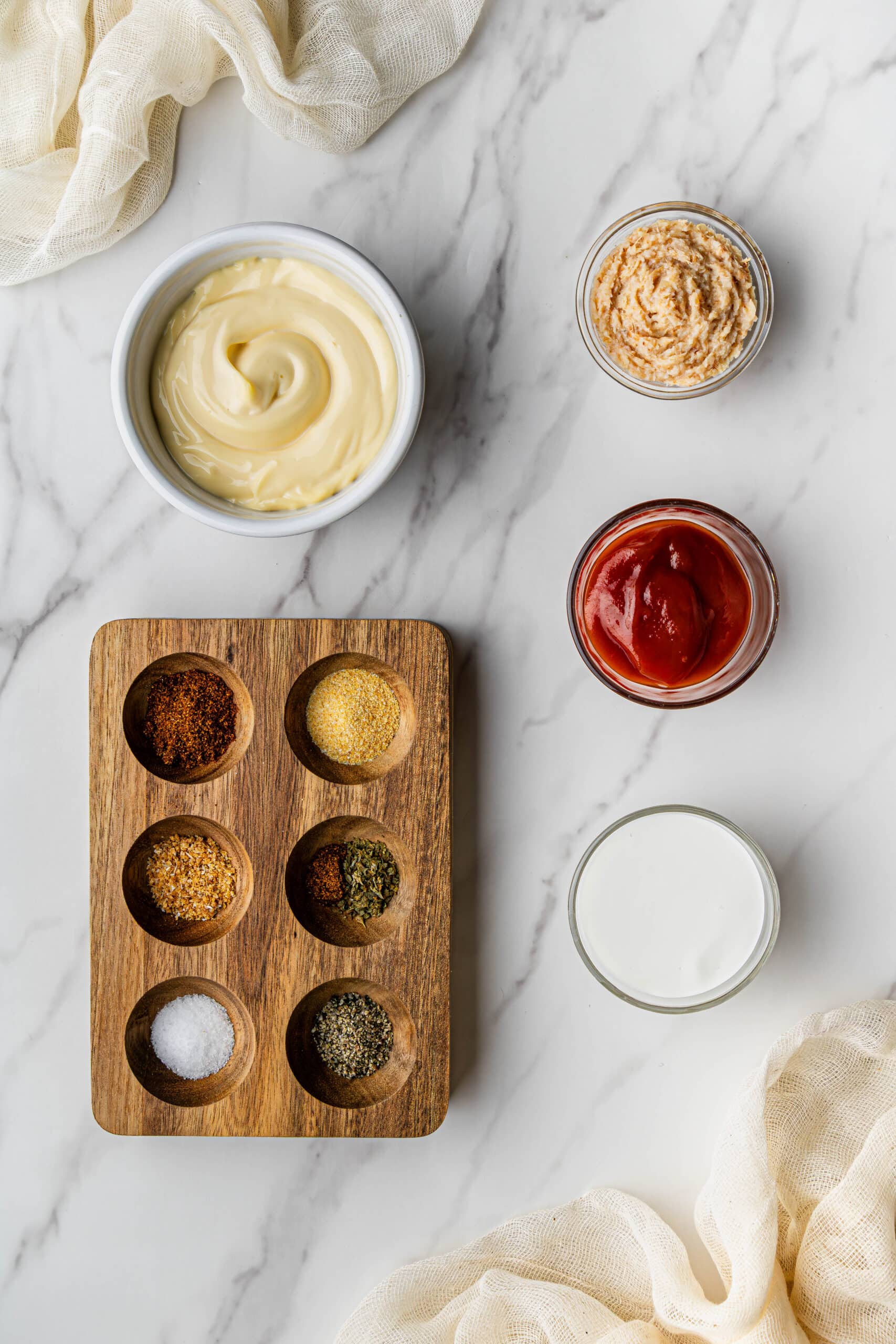 Flat lay shot of the ingredients to make the outback Bloomin' Onion Sauce copycat recipe, all placed on a marble surface.