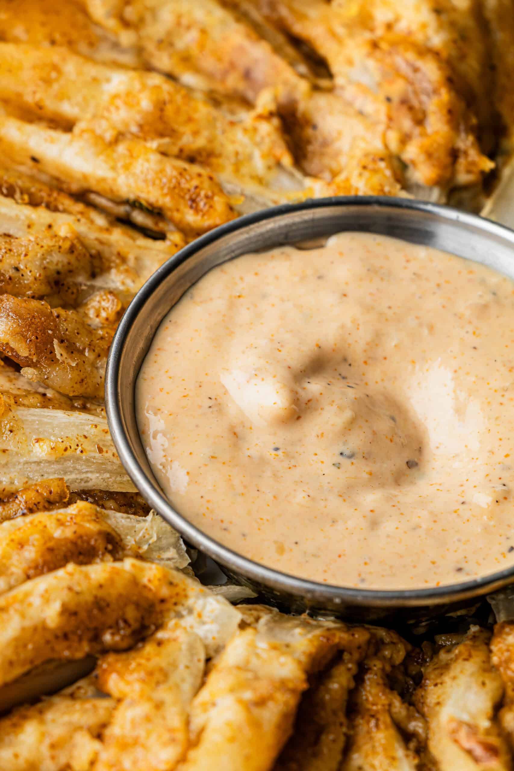 Closeup shot of a small bowl of the Bloomin' Onion sauce nestled in the center of crispy outback steakhouse Bloomin' Onion sauce copycat recipe