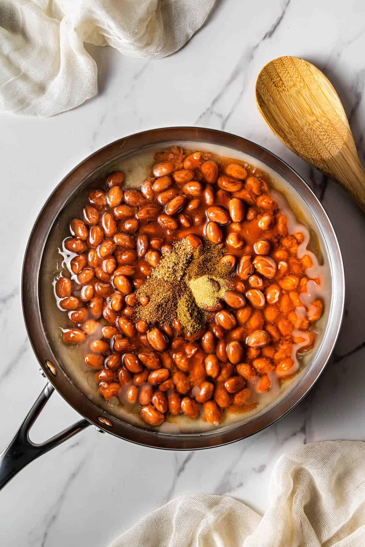 A skillet with beans and spices added to it.