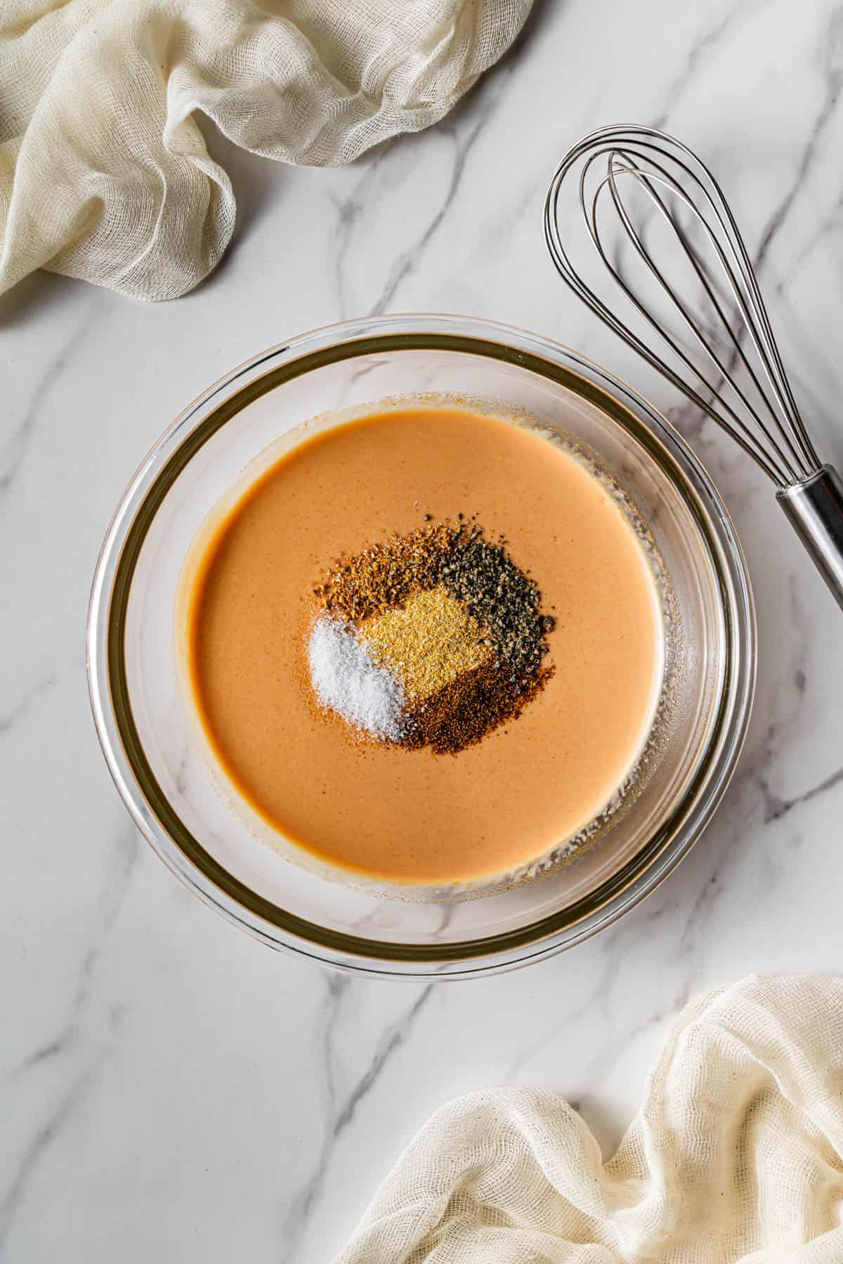 Flat lay shot of a glass bowl with the sauce with spices in it.