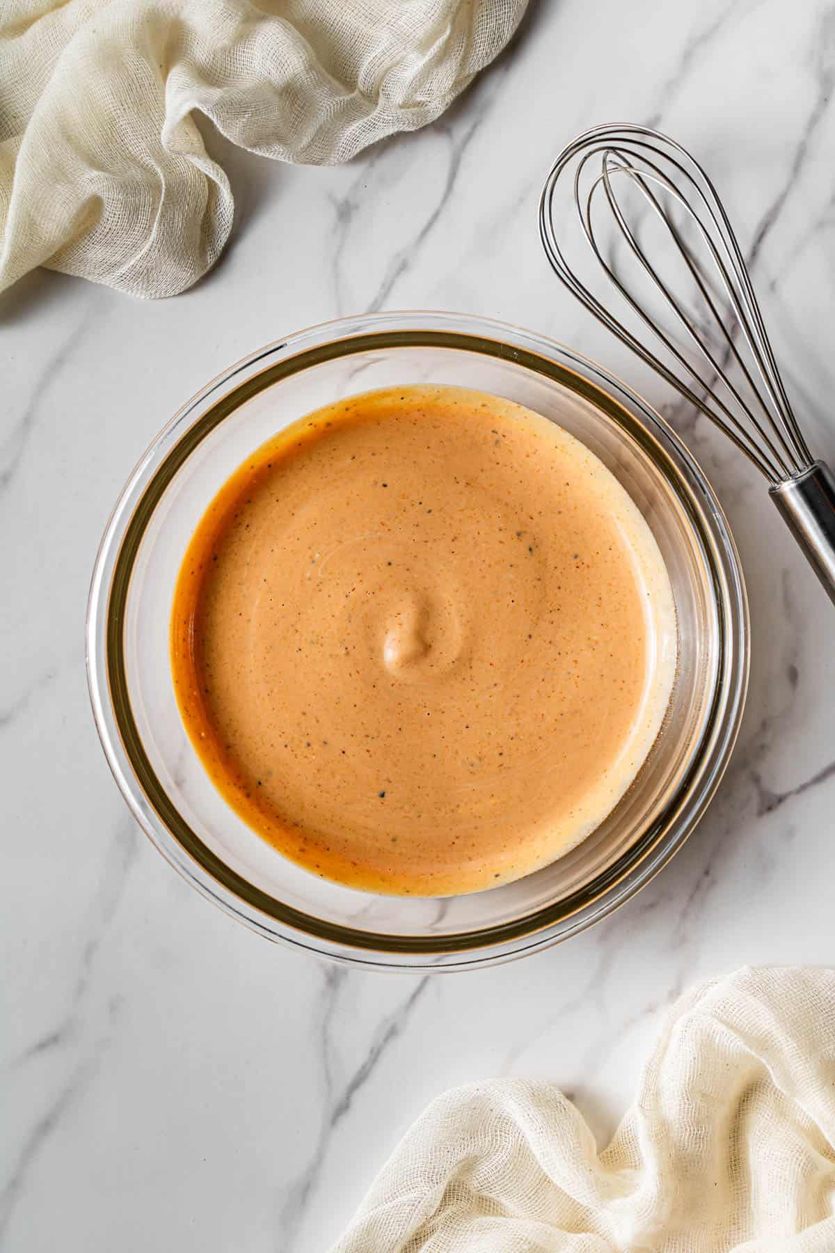 A glass bowl with the finished Copycat Raising Cane sauce in it.