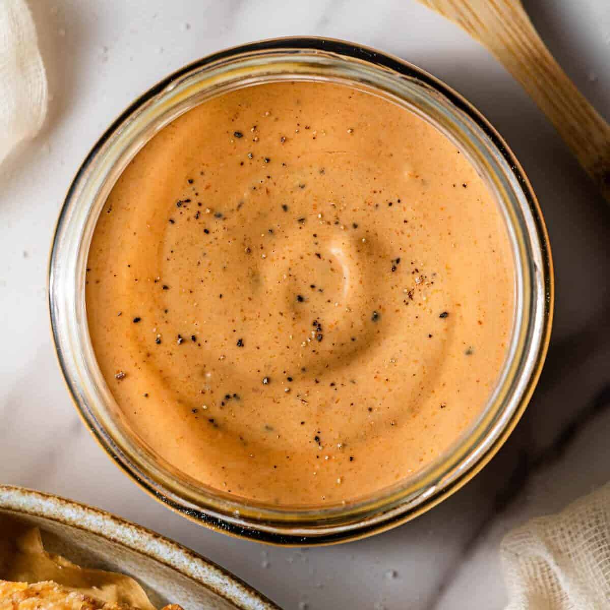 A glass bowl with Copycat Raising Cane sauce in it.