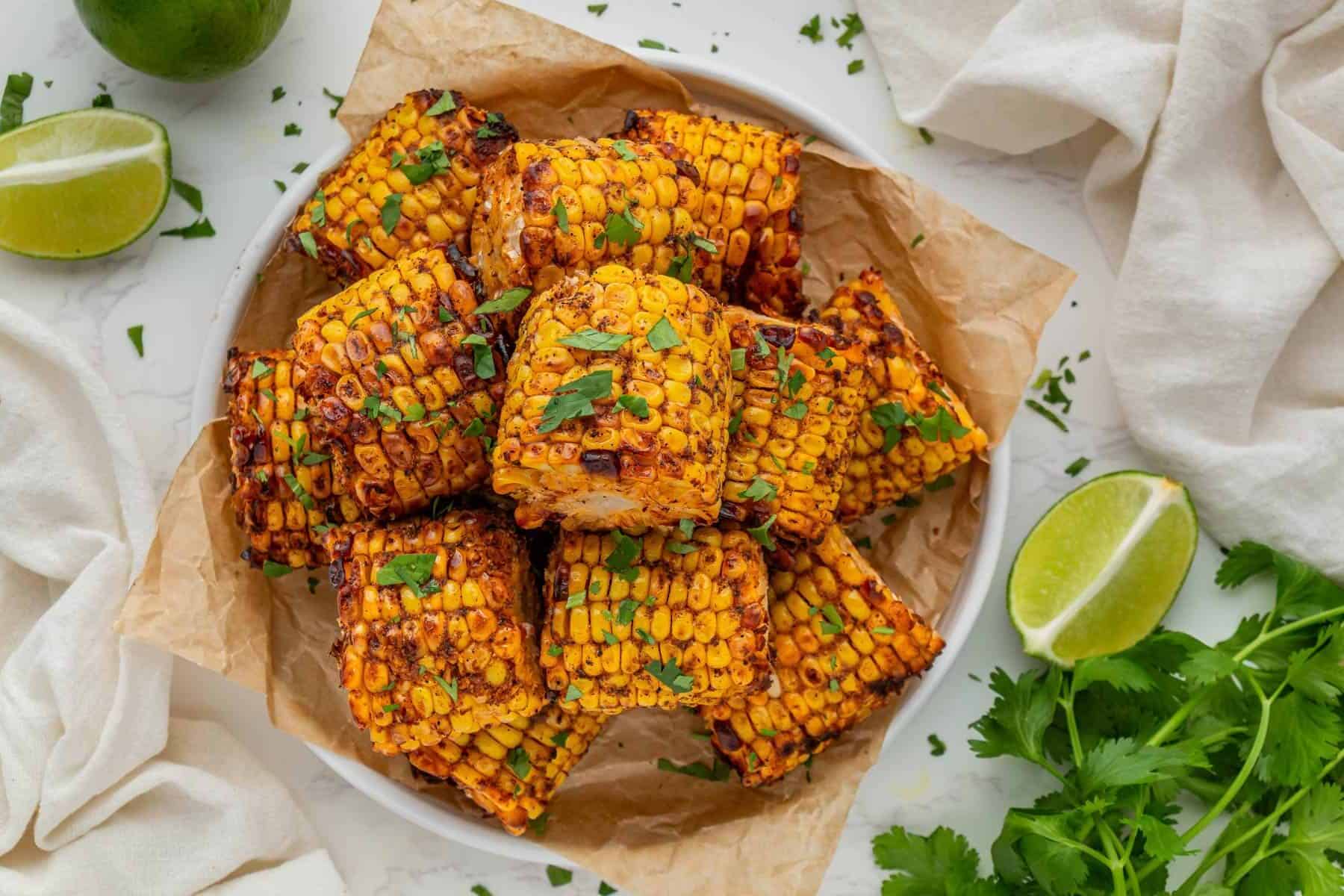 Bowl of spicy grilled Wingstop Cajun Corn Recipe garnished with cilantro and lime