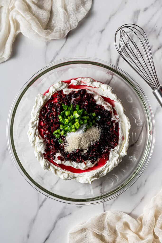 adding cranberries, jalapeño, and seasonings to cream cheese mixture for copycat La Terra Fina cranberry jalapeño dip