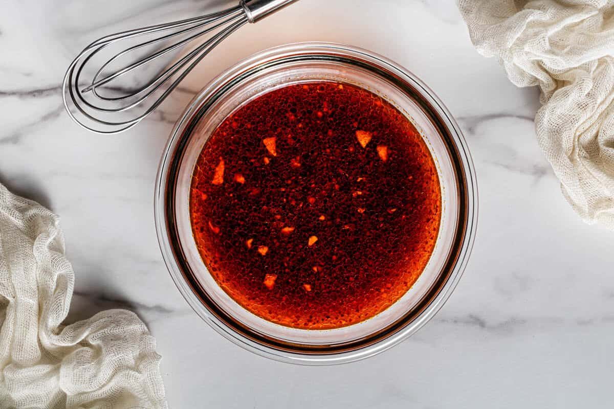 Homemade kung pao sauce whisked together in a glass bowl with a small whisk