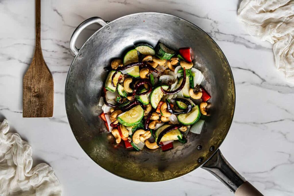 Vegetables, cashews, and dried red chilies with kung pao sauce added to the wok