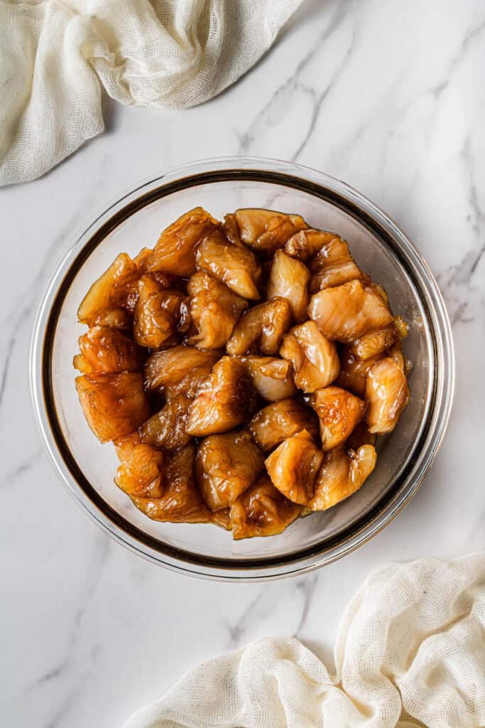 Chicken pieces marinating in soy sauce mixture for velveting