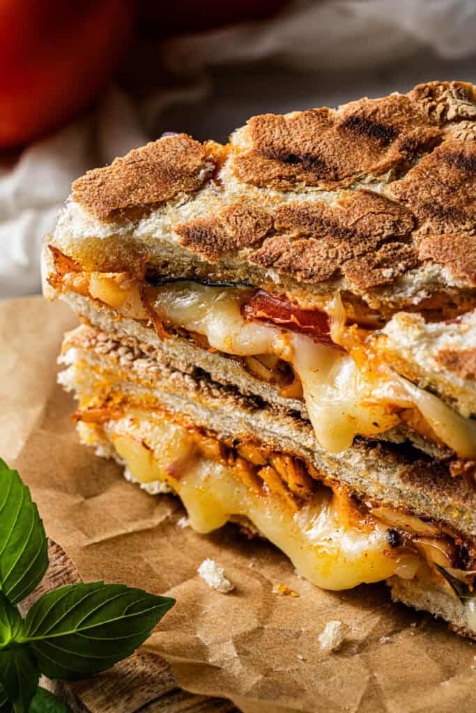 Close-up of toasted chicken panini with melted cheese and smoky chicken filling