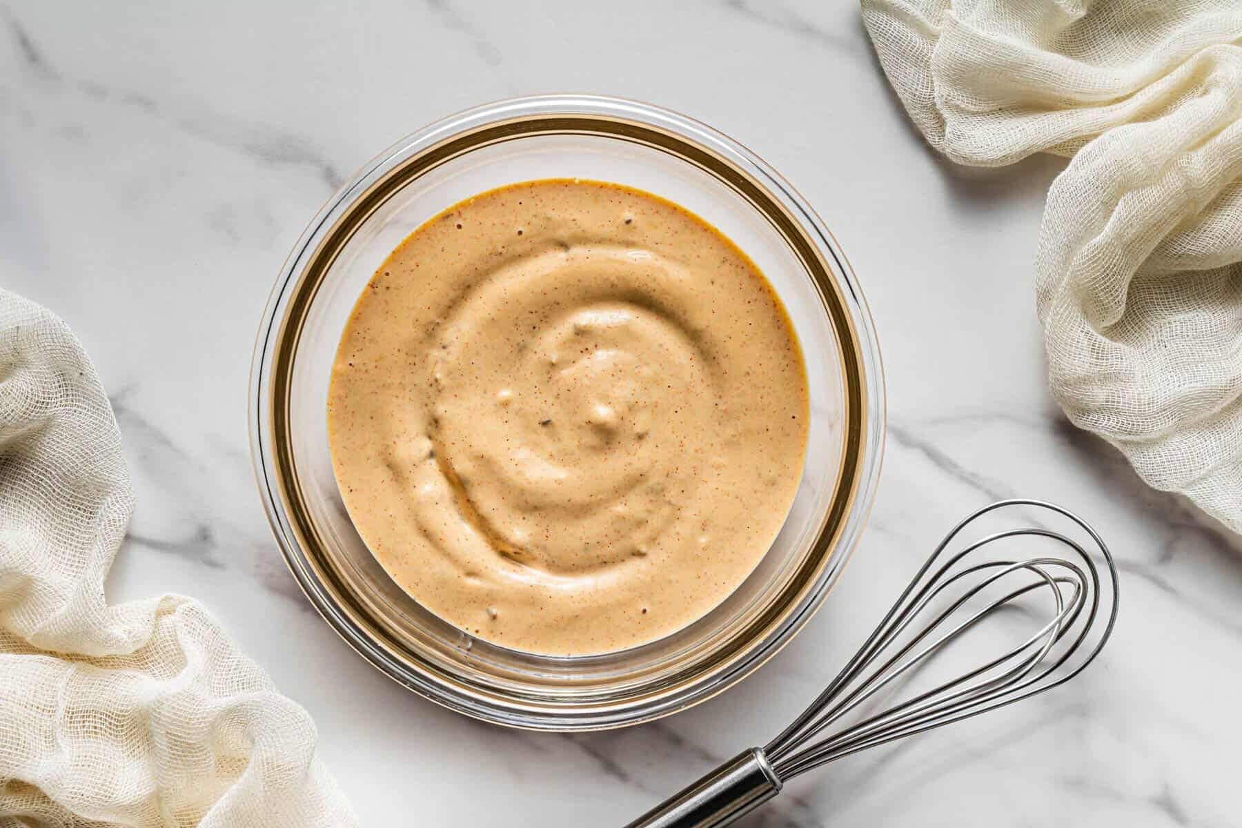 Creamy homemade chipotle mayo mixed in a bowl with whisk