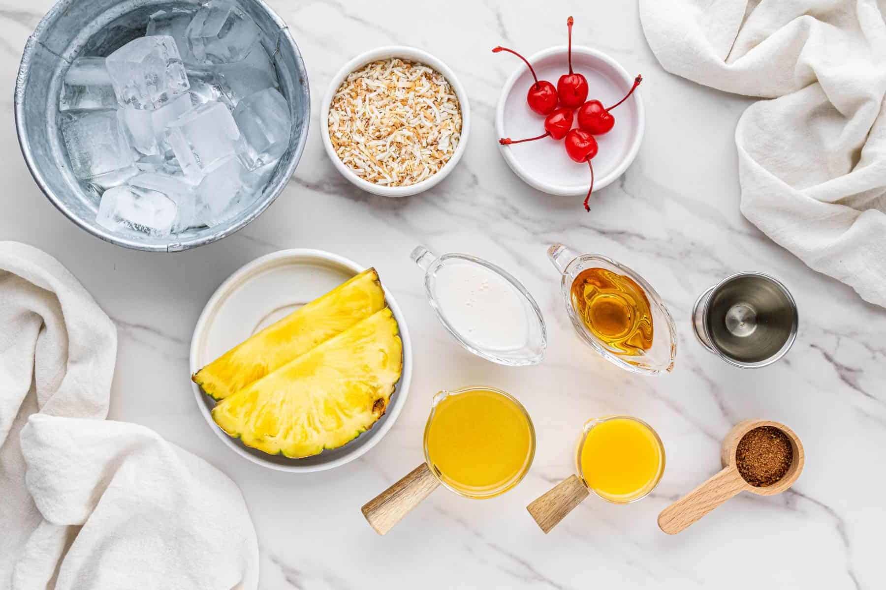 overhead view of cheddar's painkiller cocktail ingredients in individual bowls and cups