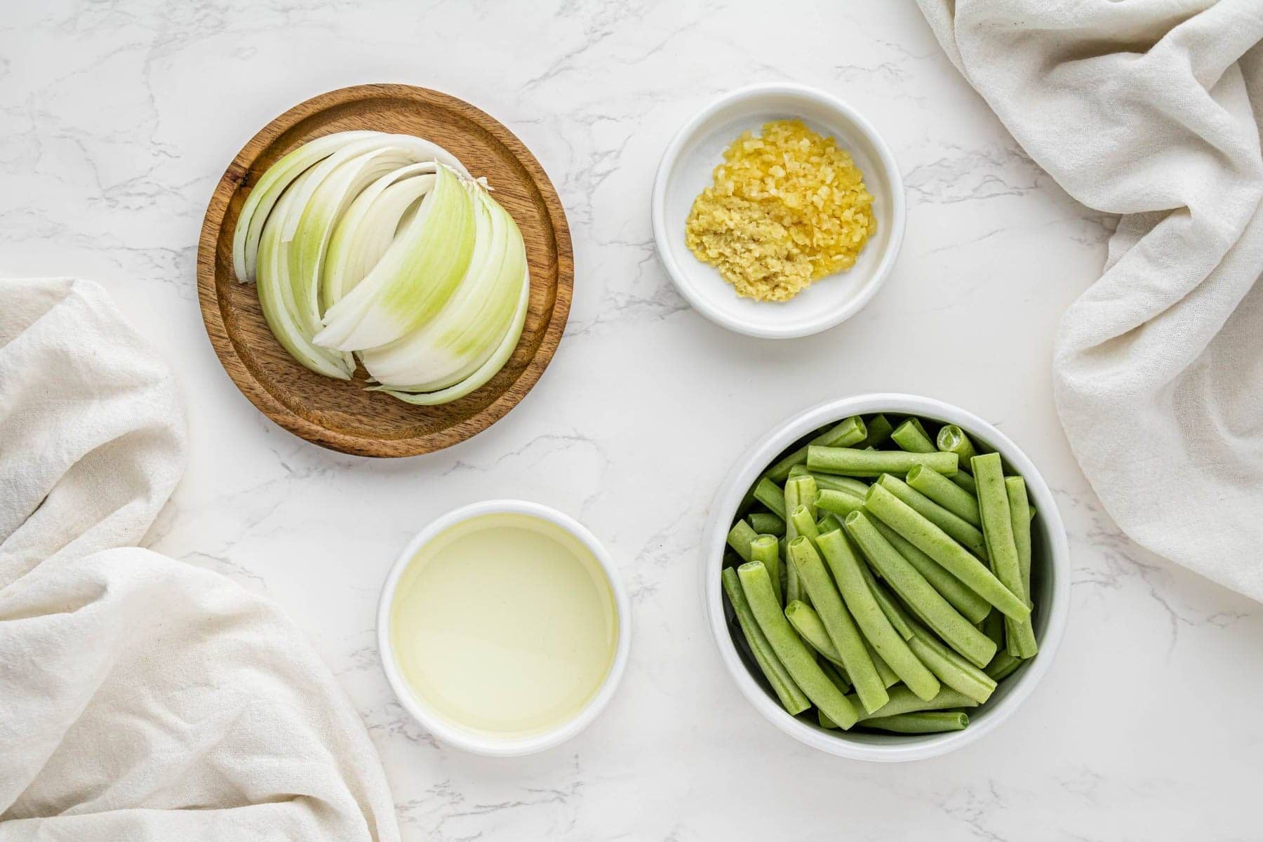 overhead view of string bean ingredients in bowls and spoons
